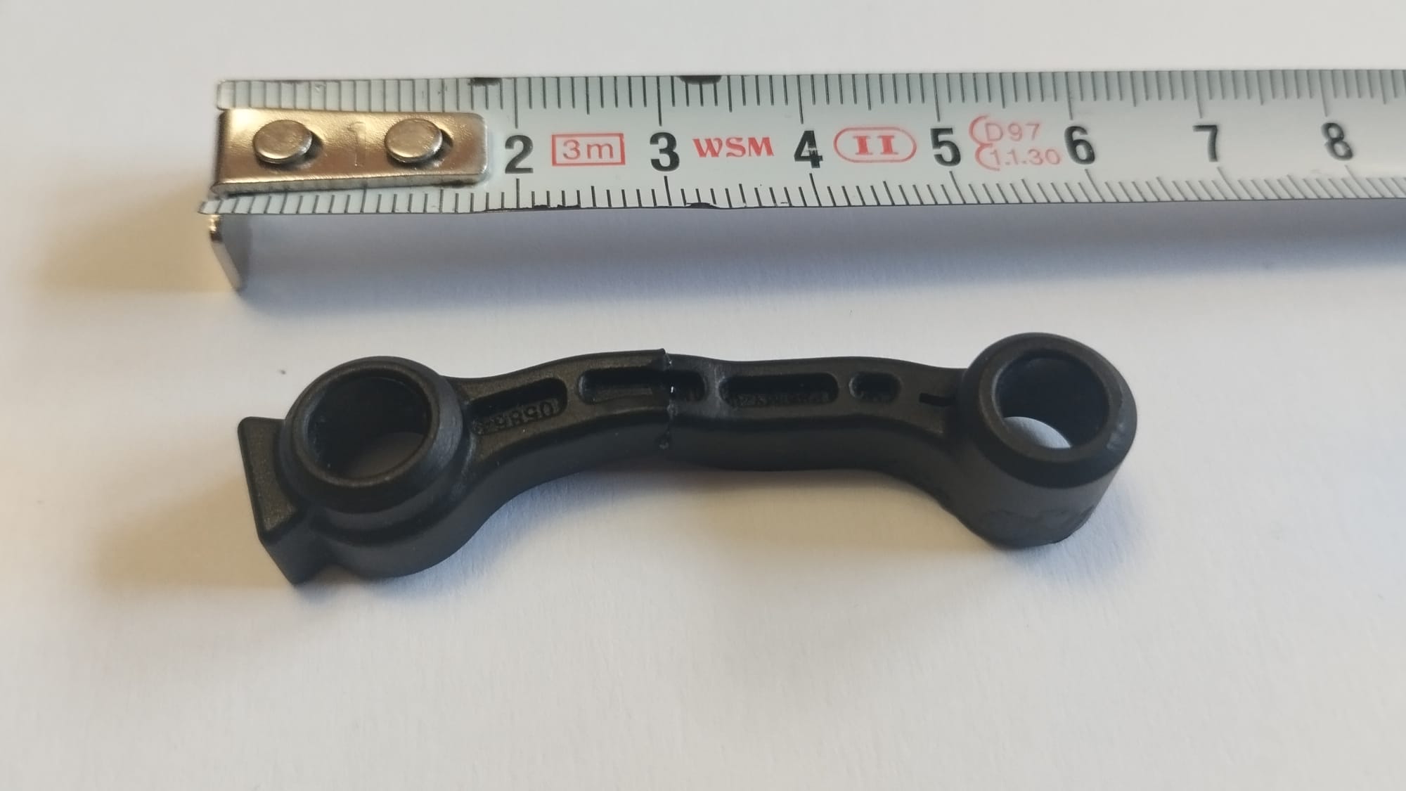 Pieza mecánica técnica fabricada con impresión 3D, detalle con referencia de escala